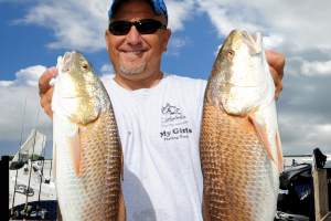 Brian Sanders holds up a couple Chokoloskee redfish