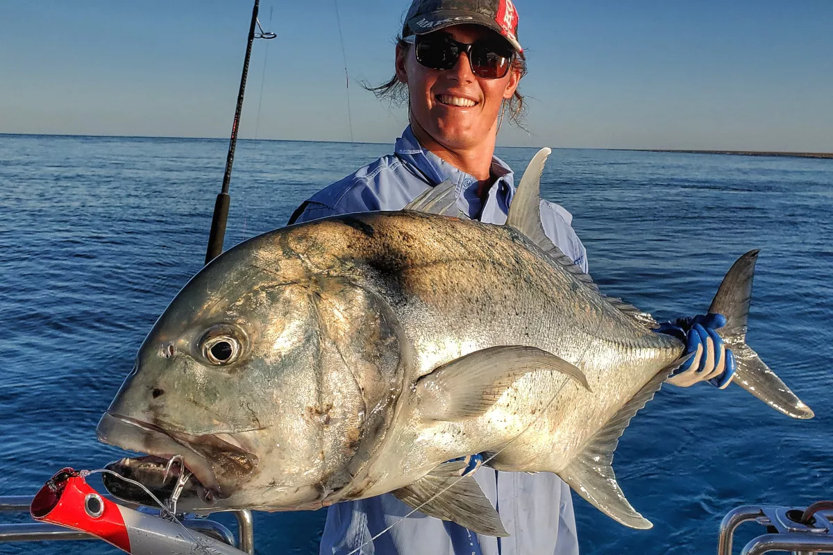 Halco popper hanging from the mouth of a giant trevally