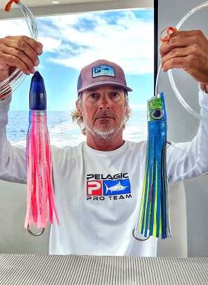 Kevin Hibbard holding lures with rubber skirts and vinyl skirts